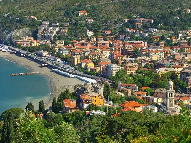 the seaside town of levanto with an old castle and church and some beach 
