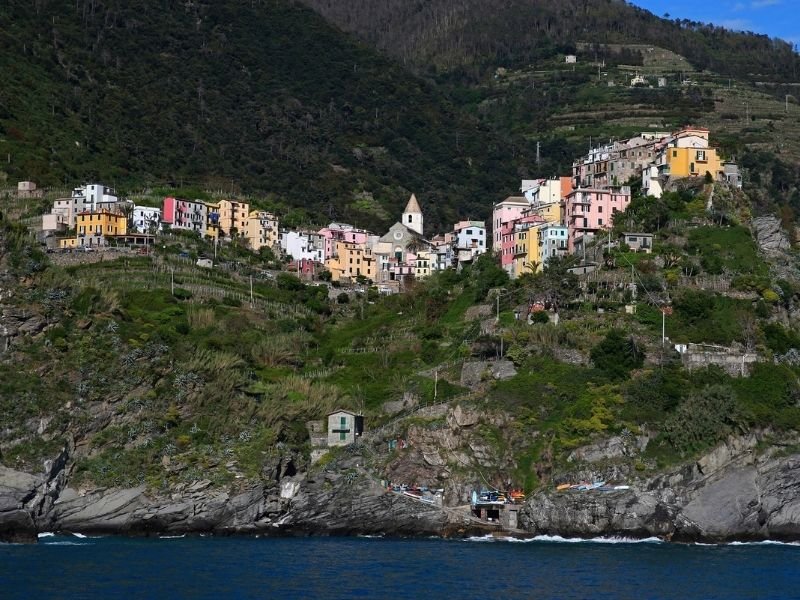 the charming town of corniglia as seen perched above the water's edge on the cliffside