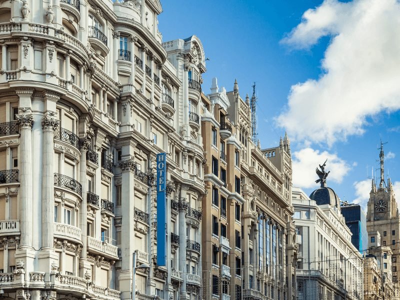 gran via of madrid with famous facades of buildings and clocks and angel towers