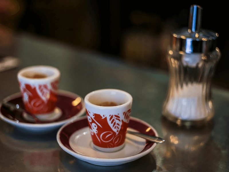small espresso cups (red and white) and a sugar dispenser in madrid