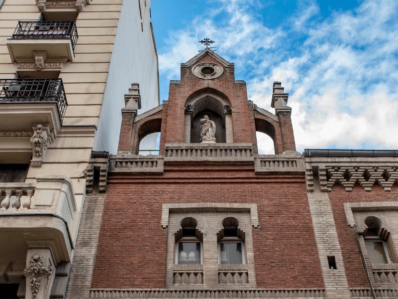 la latina madrid street scene with a famous church and statue