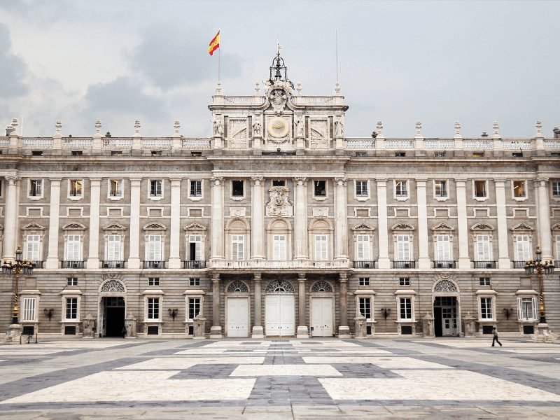 the grayish white fancy exterior of the royal palace of madrid, the former home of the royal family and one of the most popular madrid tourist attractions on a madrid itinerary
