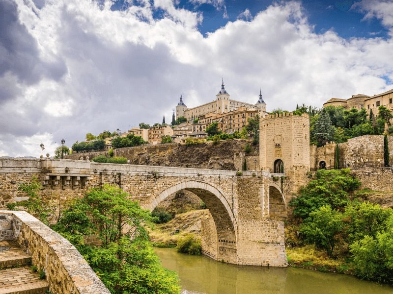 view of toledo bridge and the city up on the hill in the beautiful unesco city of toledo