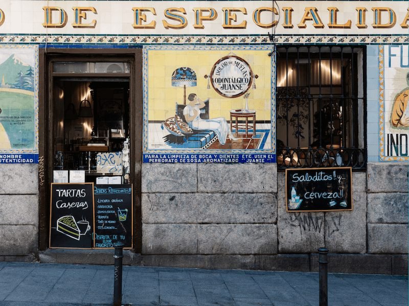 a beautiful storefront in malasana barrio of madrid with traditional typefaces and art