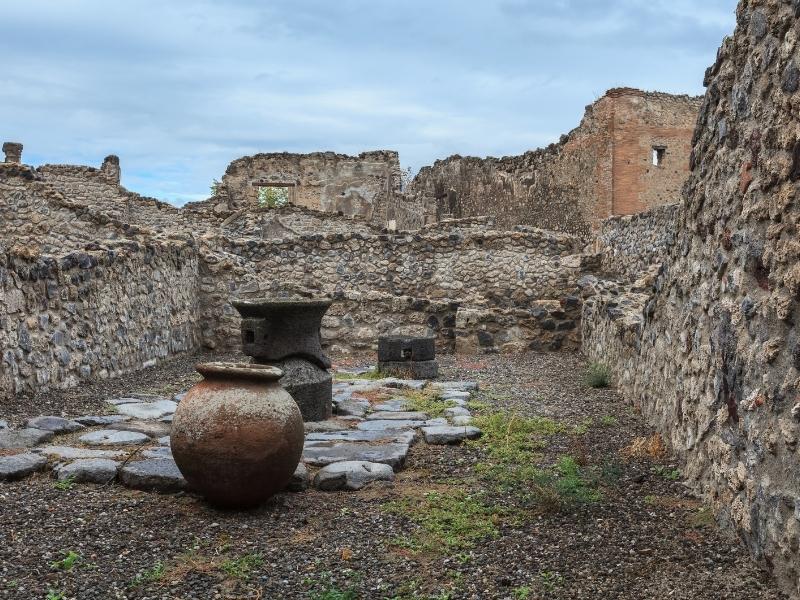 detail of some of the ruins of pompeii including vases and stone walls