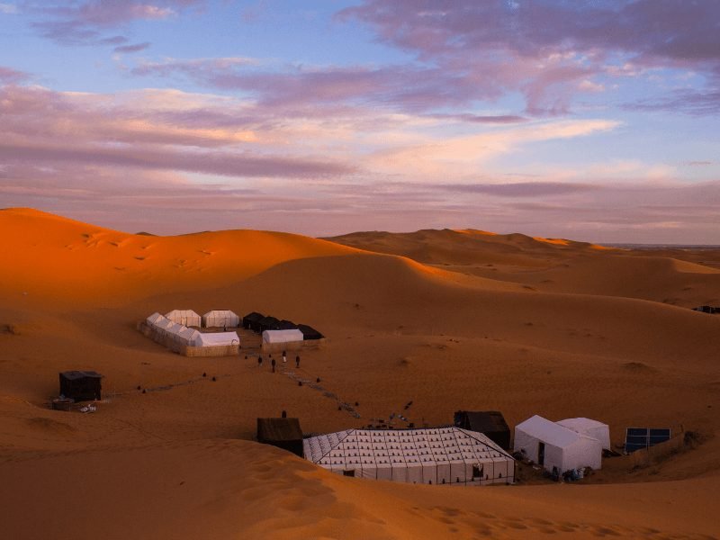 a desert camp at sunset in morocco