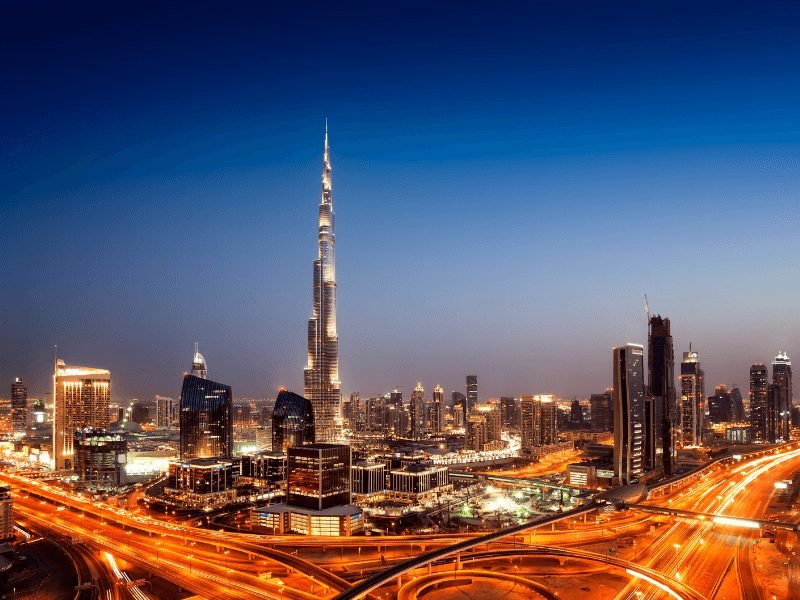 busy roads of dubai at night, showing movement of the city after dark, with the burj khalifa as the landmark of the city centered in the photo