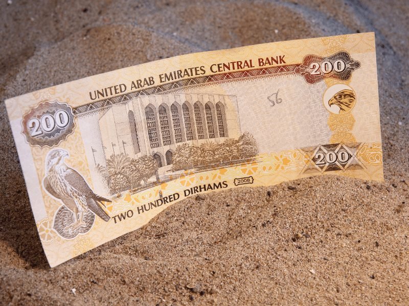 a banknote for the emirati dirham for 200 dirhams in the sand