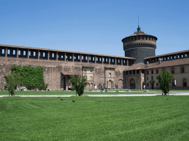 the courtyard of sforza castle in milan, grass and fortress on a clear day