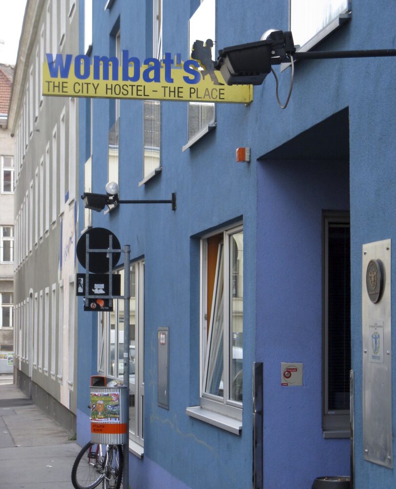 exterior of wombats hostel in vienna, blue building with blue and yellow sign