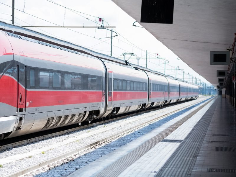 a red train pulling into naples train station in italy