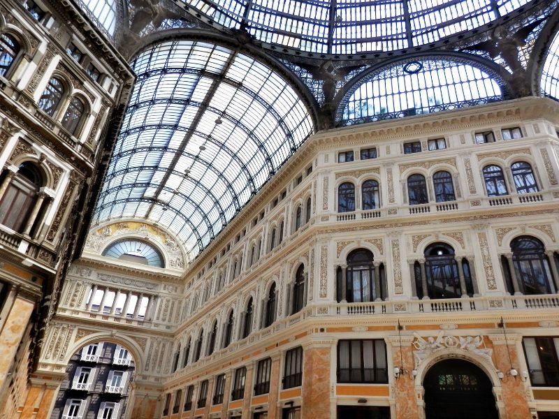 the interior of the galleria umberto in naples with glass covered ceiling with ironwork and interior that is very ornate and beautiful