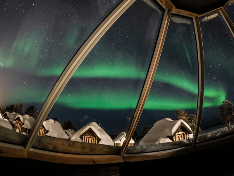view from the inside of a glass igloo in finland looking at the northern lights