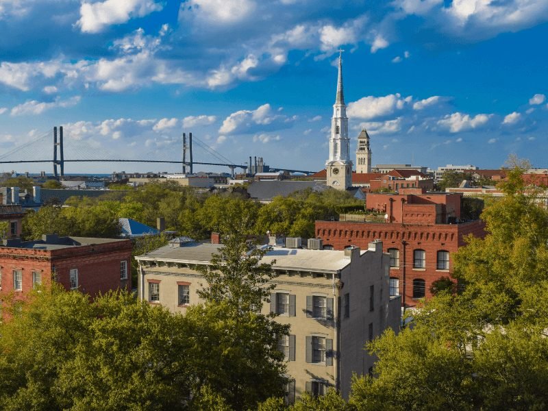 view of savannah's historic buildings, churches, and bridges from above on a sunny day