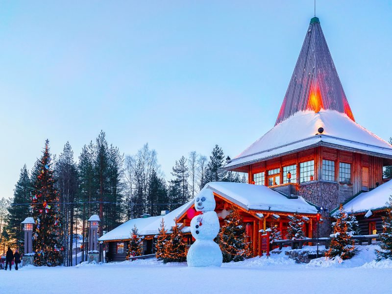 snowman in front of santa claus village in rovaniemi