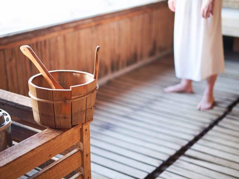 sauna in winter with person in a robe in the background