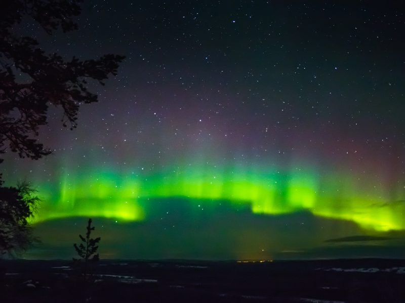 Rovaniemi in winter with neon colors of the aurora borealis