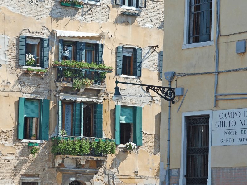 yellow buildings with exposed brick showing from wear and tear in venice's old jewish ghetto