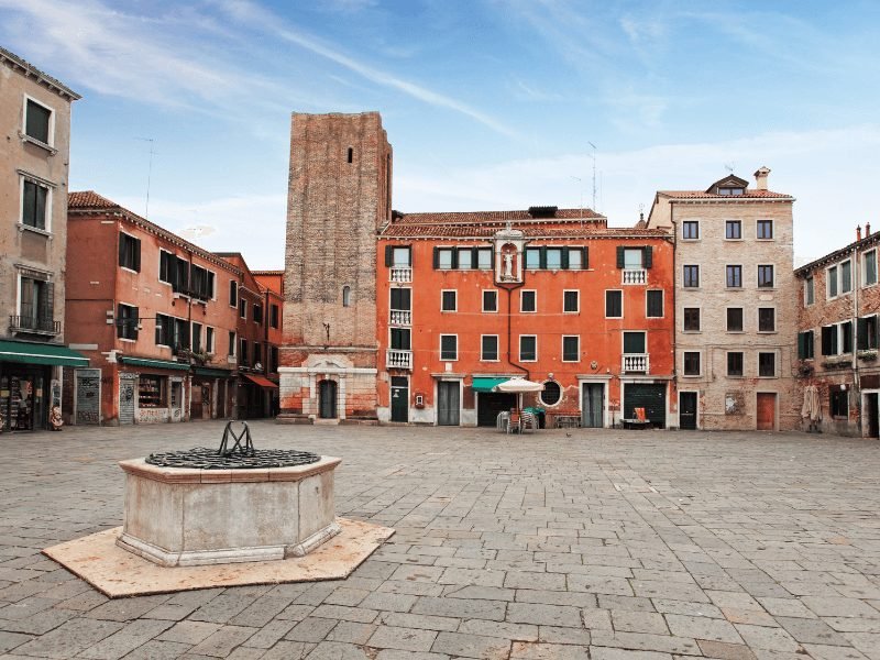 the square of campo santa margherita, empty, with colorful buildings around the plaza