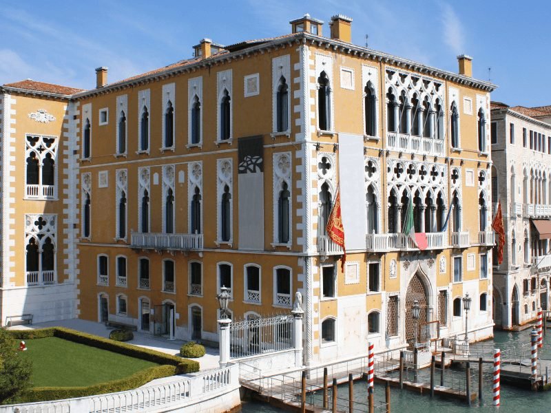 famous accademia gallery in Venice with a yellow building and arched windows