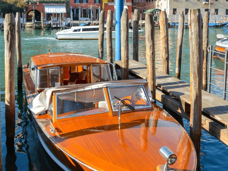 a typical venice water taxi - a wooden-glossy boat with a headlamp