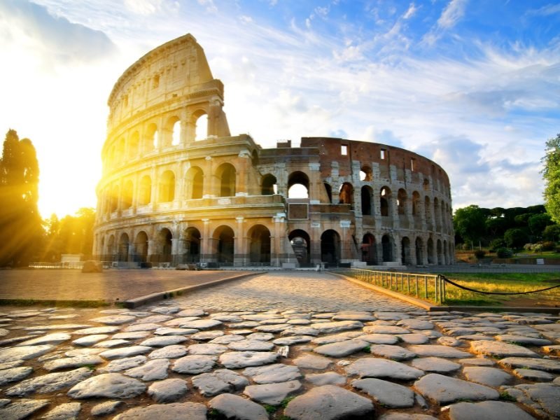 crowd free colosseum with sunburst visible in the early morning