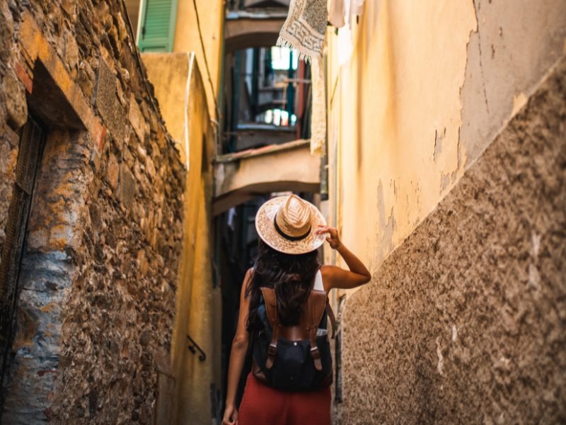 woman wearing a hat and a backpack in an italian city