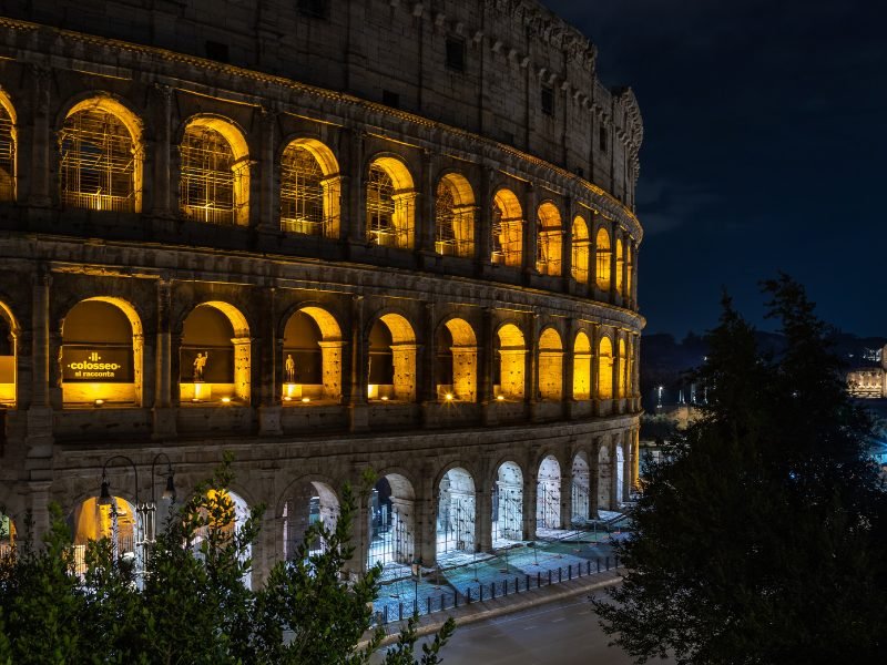 the Colosseum at night all lit up in Rome at night