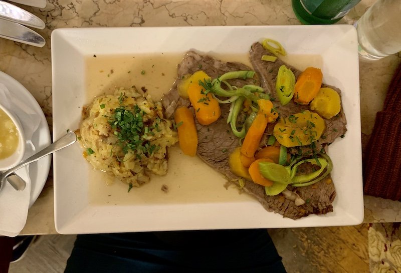 a plate of boiled beef with vegetables and dumplings at cafe tirolerhof