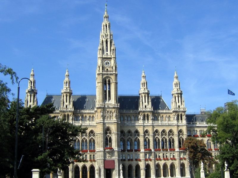 the vienna city hall with four smaller towers and one big tower on a sunny day