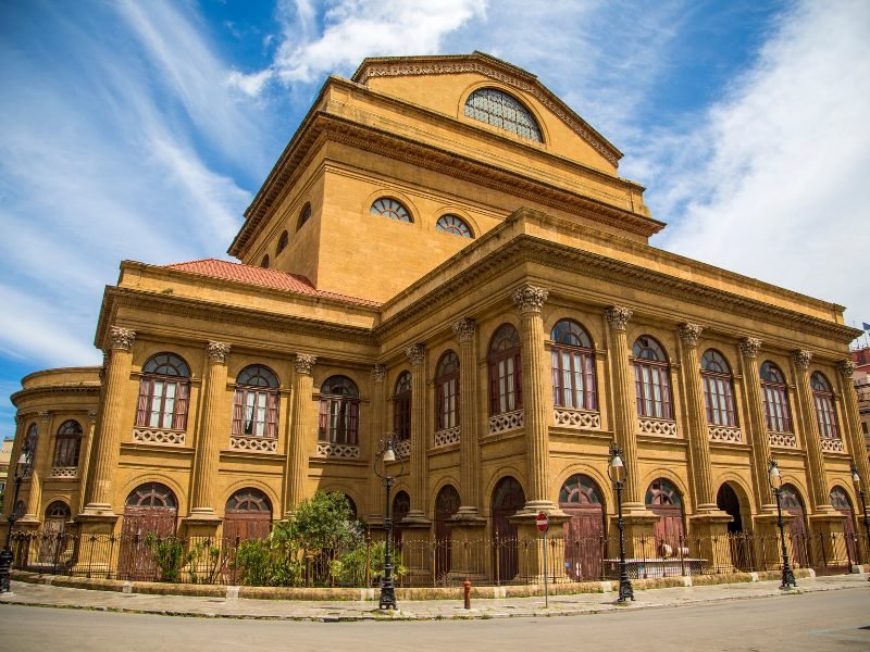 terra cotta colored theater slash opera house, the largest such in italy and the third largest in europe, on a sunny day in palermo city center