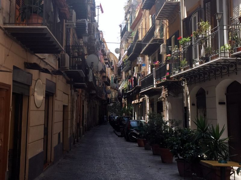 deserted side alley in palermo with balconies and flowers and satellite dishes