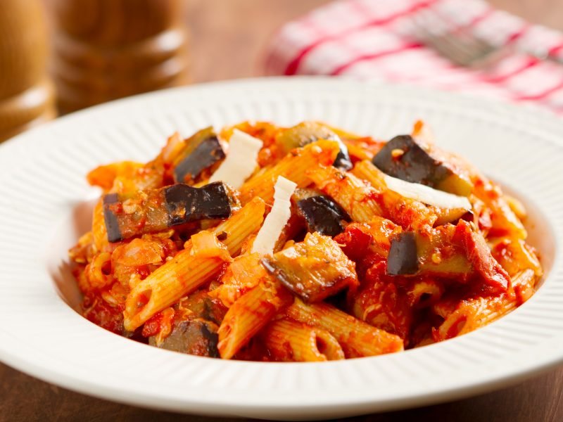 pasta with eggplant and red sauce and grated cheese at a restaurant in sicily