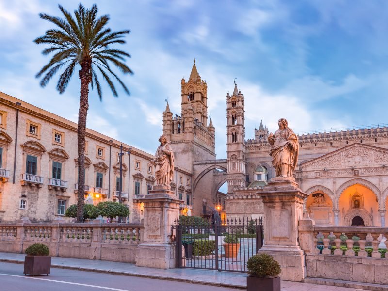 the downtown area of palermo sicily the capital of the island with palm tree and ornate architecture and cloudy sky
