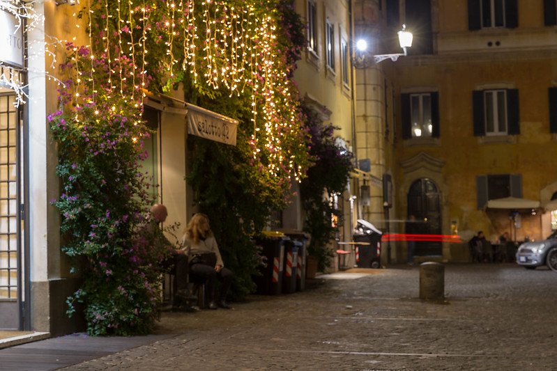 the exterior of salotto 42 in rome at night with lights in front.