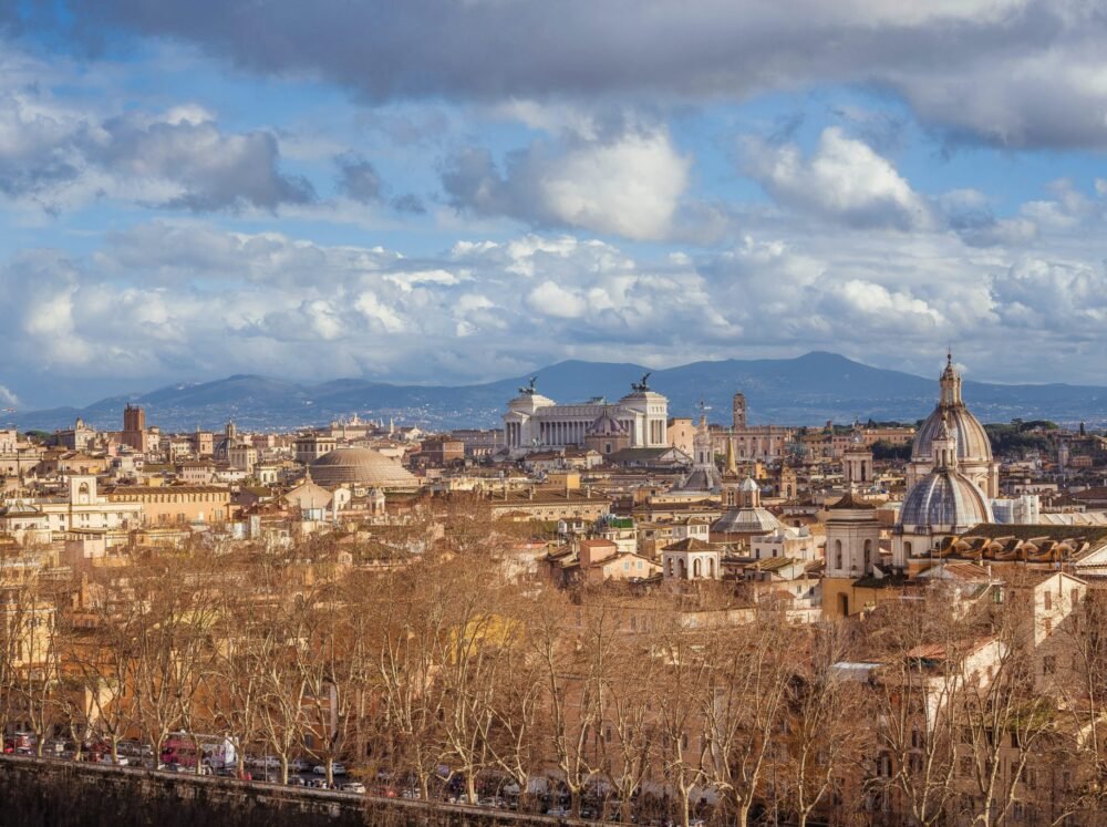 bare trees as part of the landscape of the city center of rome in winter with altare della patria visible in the distance