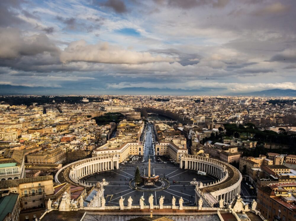 view over st peters square with christmas tree, obelisk during the winter months in rome with cloudy dark winter sky