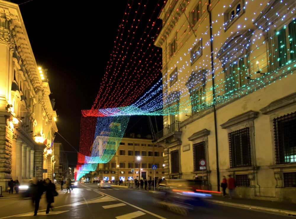 white, red, and green christmas lights along the via del corso in the colors of the italian flag at night in winter