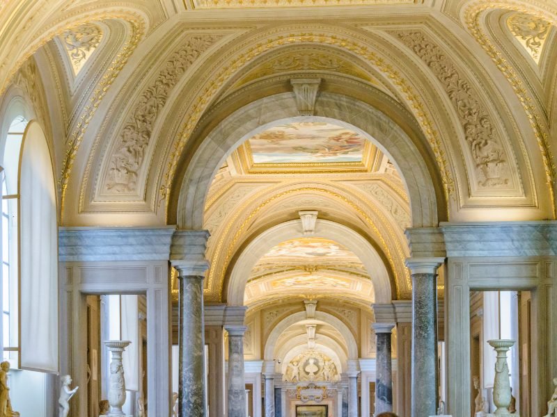 view of the arches and sculpture art pieces in some of the vatican museums hallways