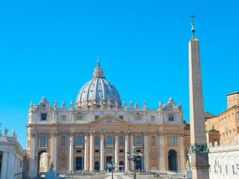 the basilica of st peter and the obelisk in the main square on a sunny day in vatican city