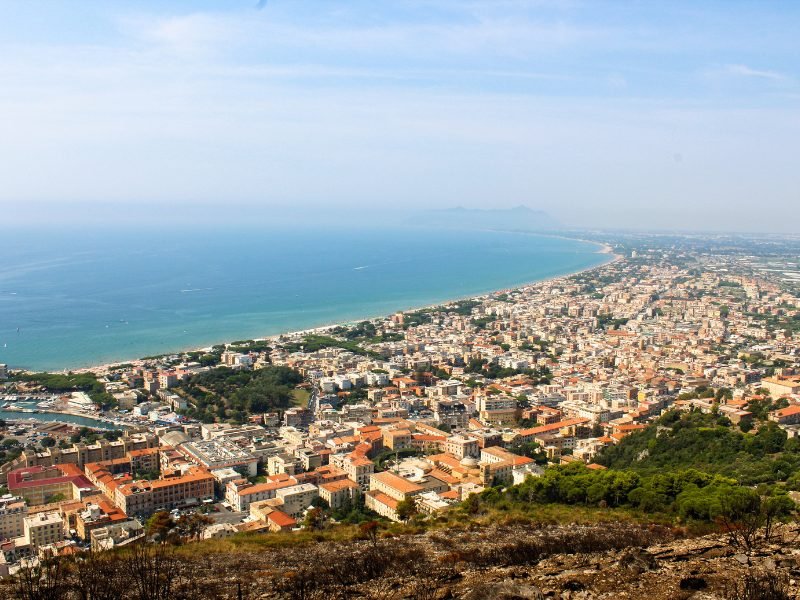 view of terracina from above with the shoreline and beautiful blue waters and beach