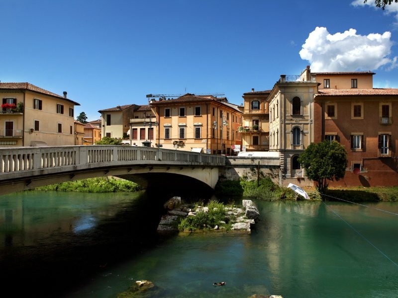 town on a river with historic old buildings on a sunny day