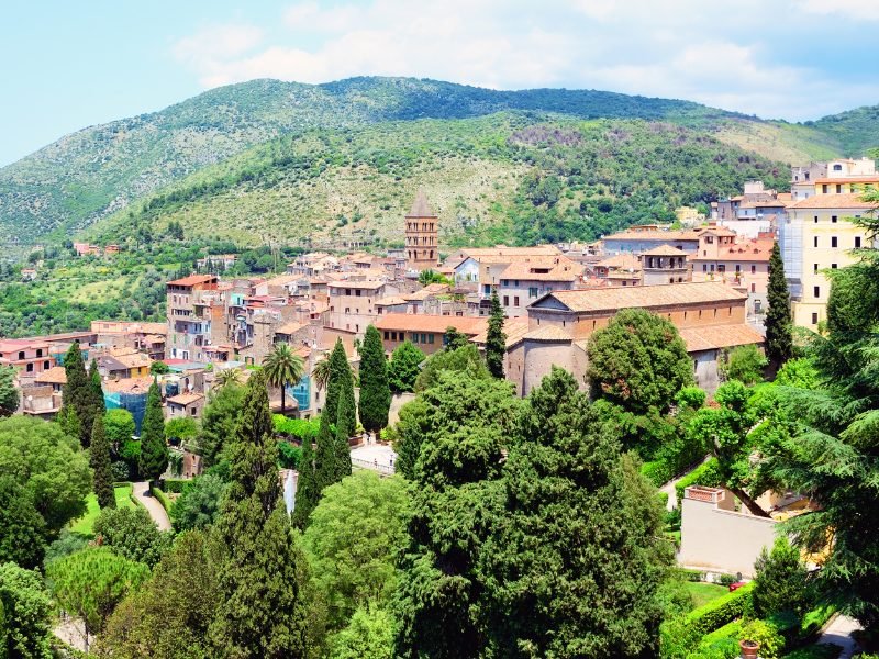 view of the hillside town of Tivoli in the Lazio region of Rome, green verdant hills and terra-cotta roof buildings on a hillside with trees