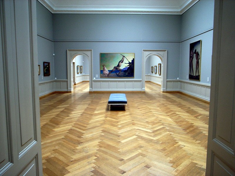 Interior of an art gallery in Switzerland with no one inside and some beautiful paintings on the wall