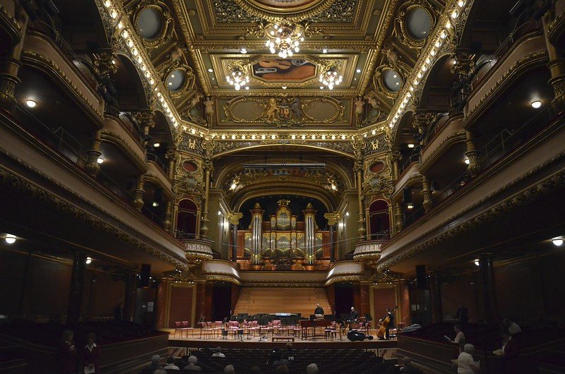 concert hall in geneva with ornate detailing on the walls and ceiling including gold detail