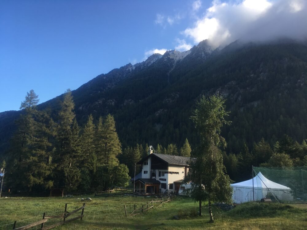 a beautiful mountain chalet and outdoor tent in the town of champex-lac with mountains behind it