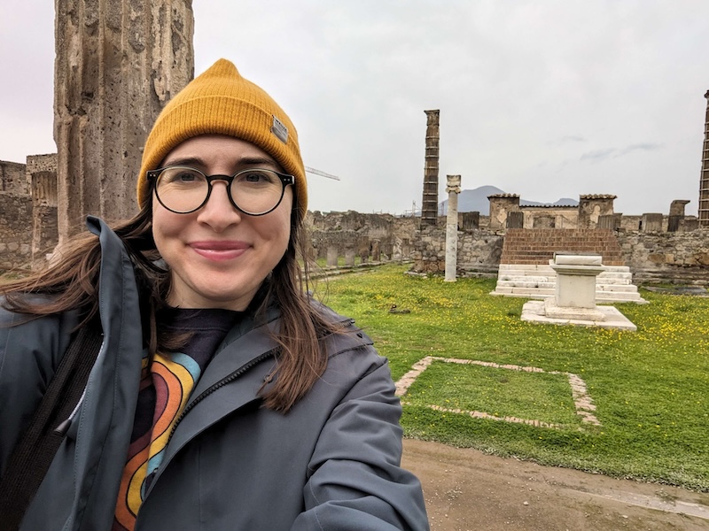 Allison Green the author of the article in front of the sights of Pompeii taking a selfie in cold weather clothing because she visited in March