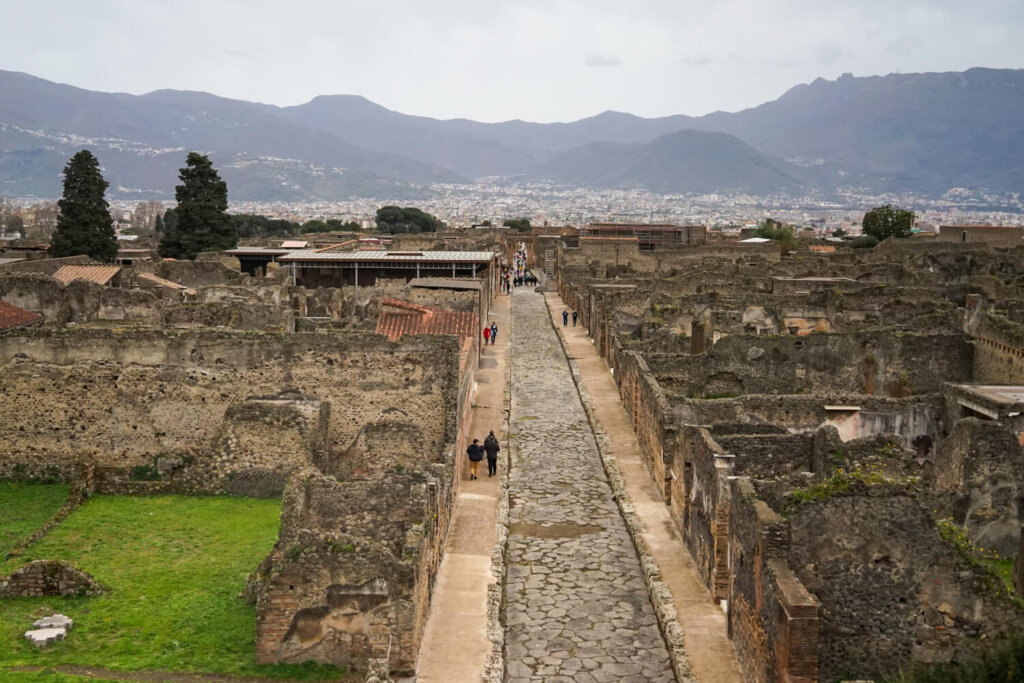 View of the Pompeii streets and ruins from a vantage point where you can also see the mountains surrounding it