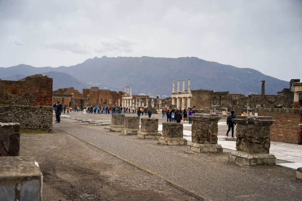 The ruins of the ancient city of Pompeii with vesuvius behind it