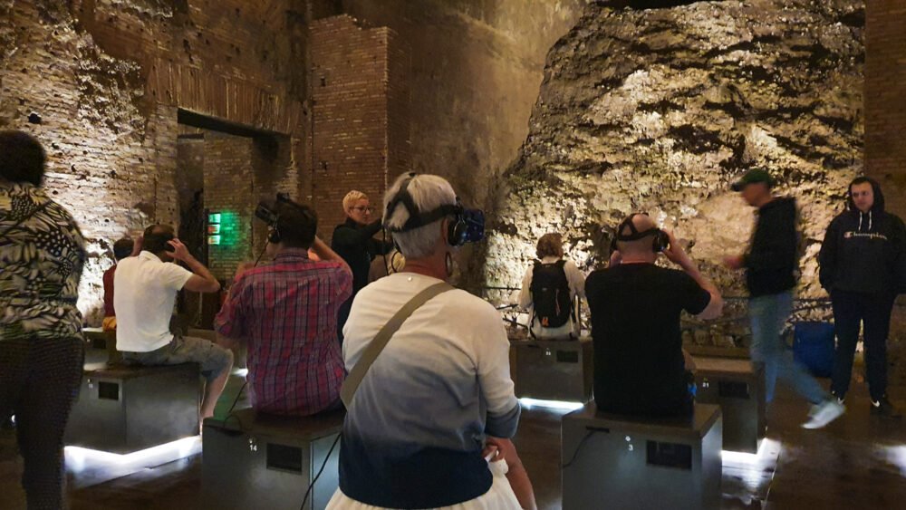 People doing virtual reality in the Guilded Vault room on a Domus Aurea tour